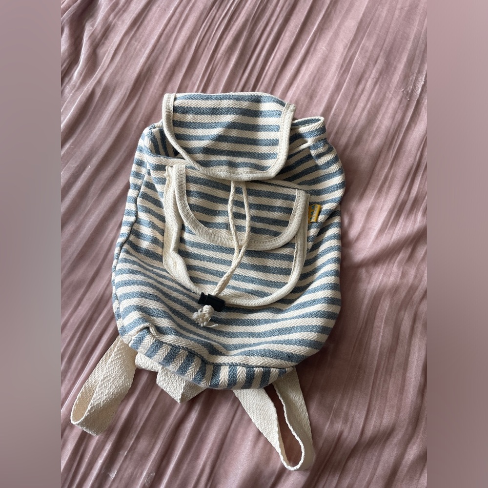 Striped blue and cream backpack with small zip pocket in front.